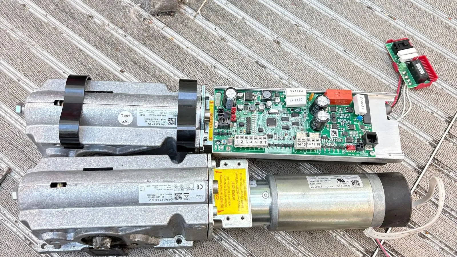 Removed automatic door operator motor, gearbox and control board laid on a mat